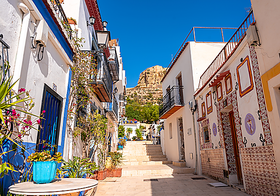 Una calle del barrio de Santa Cruz de Alicante, con el Castillo de Santa Bárbara al fondo