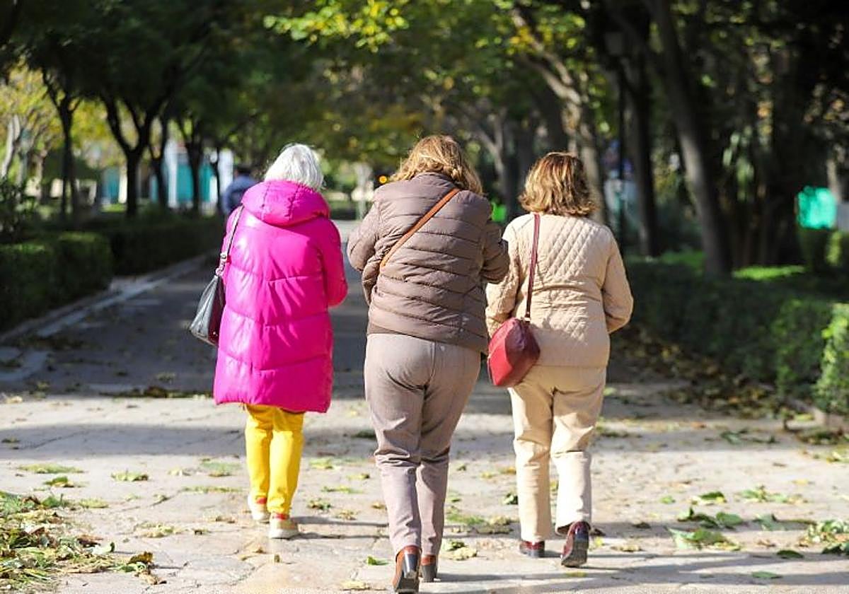 Unas mujeres se protegen del viento en Valencia.