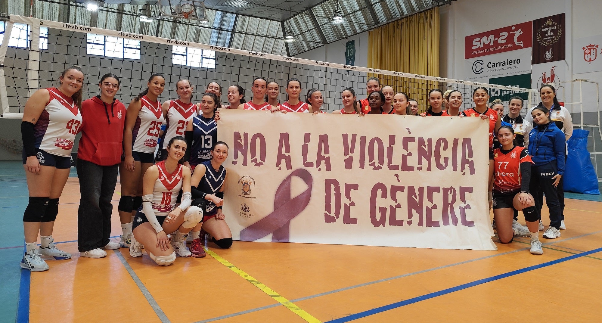 Las jugadores de los dos equipos portan una pancarta contra la violencia de género.