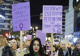 Asistentes a la manifestación con carteles.