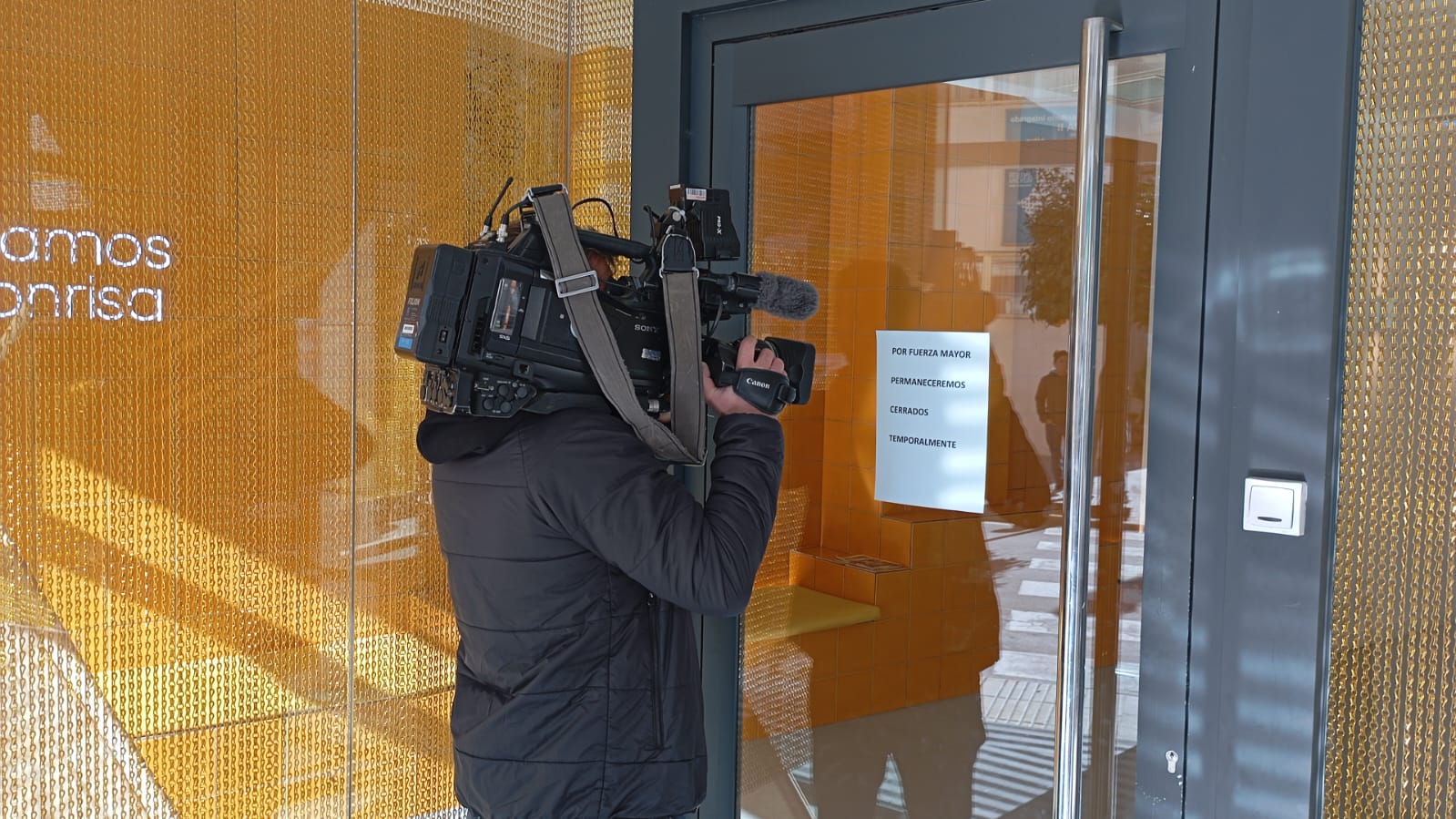 Un cámara de televisión graba la puerta de la clínica dental alcireña.