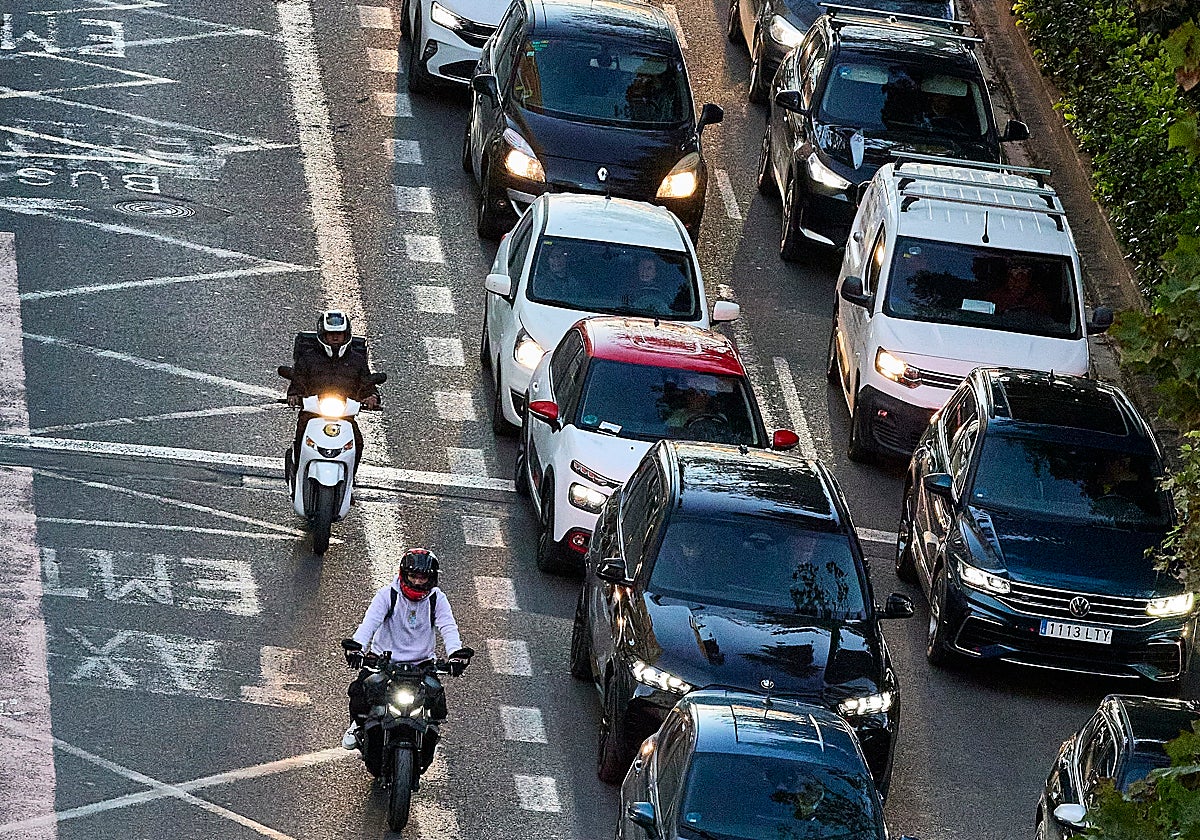 Motocicletas adelantan a una caravana de coches por una de las grandes vías de Valencia.