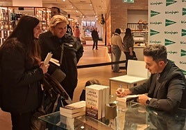 Javier Castillo charla con dos fans mientras les firma su ejemplar de 'El susurro del fuego'.