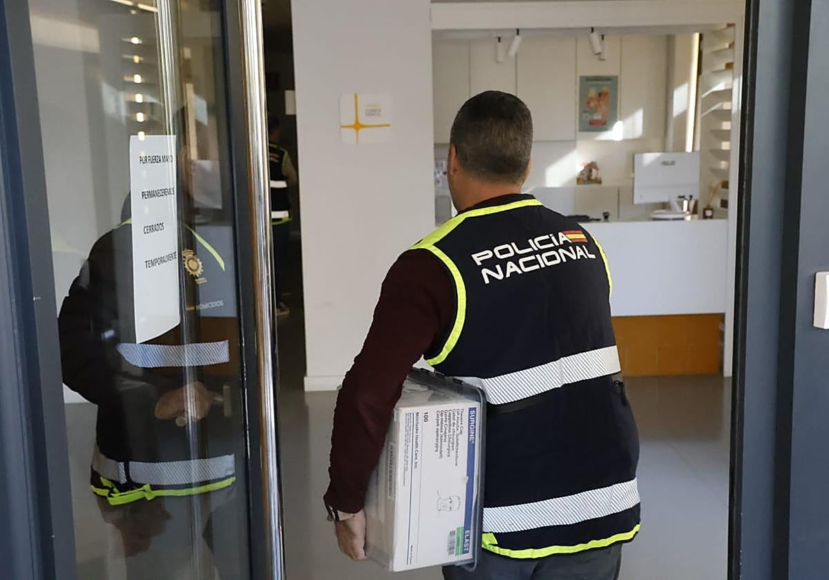 Un policía entra en la clínica con una caja.