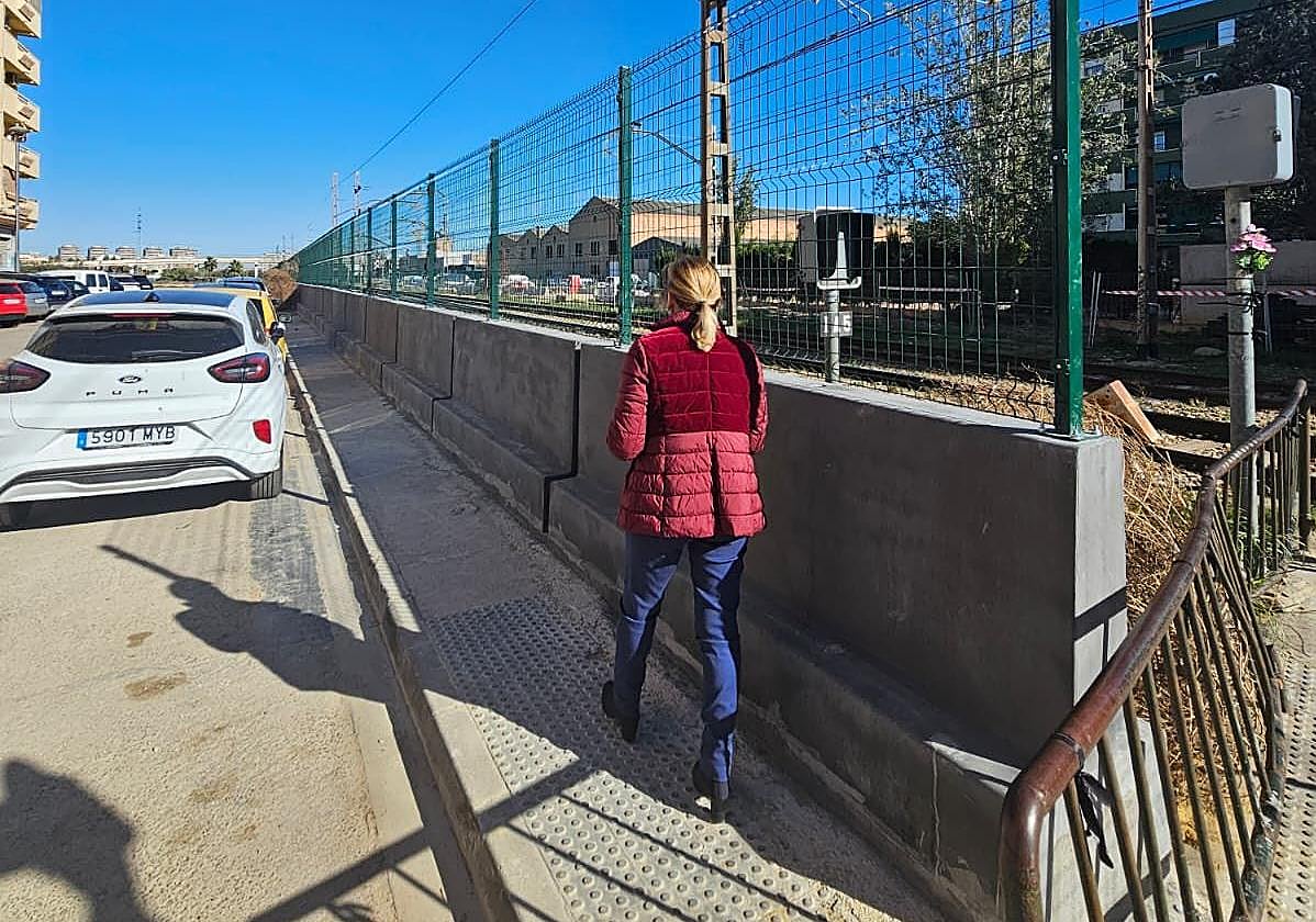 Una viandante pasa junto a la verja colocada en las vías en Alfafar.