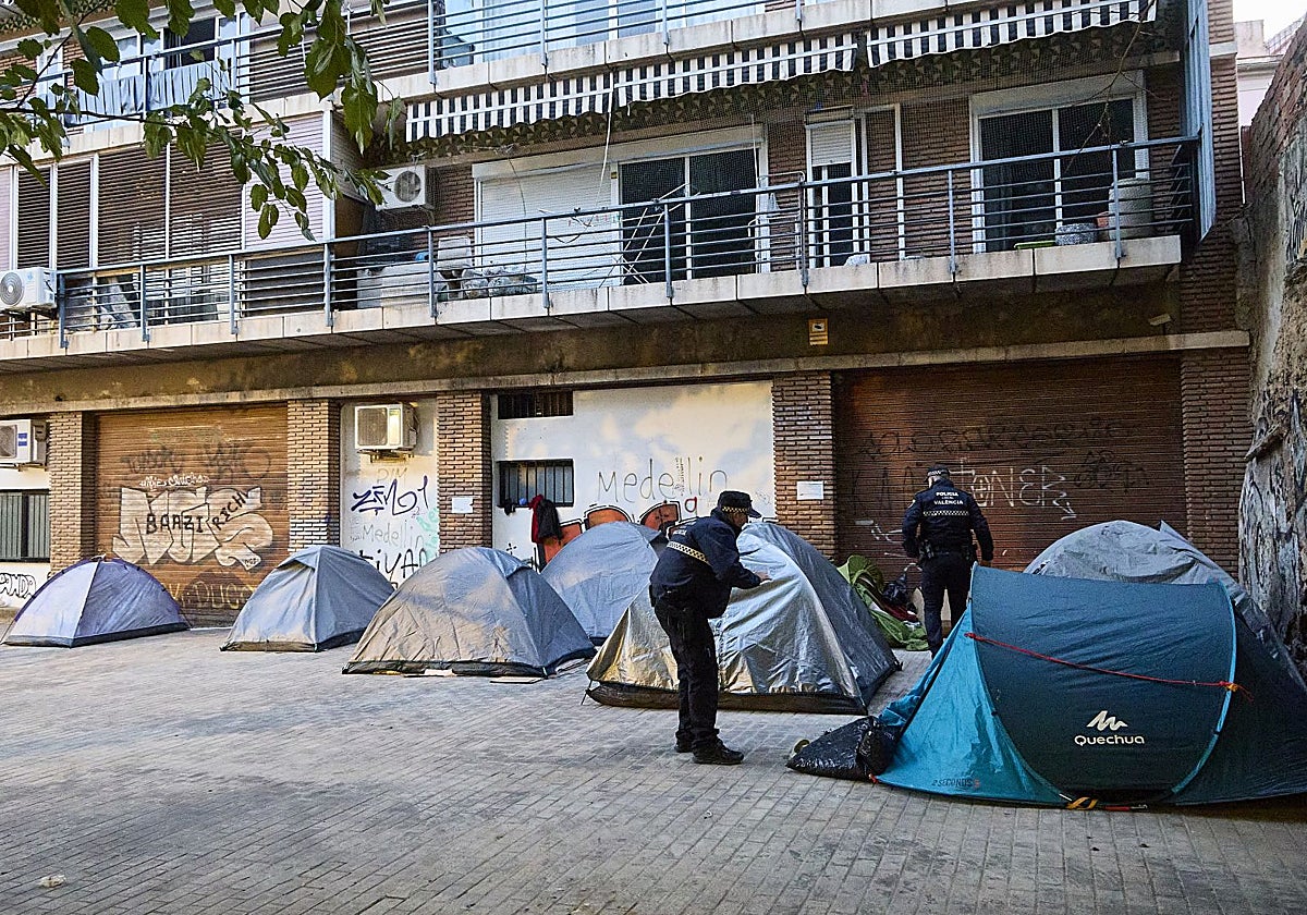 Agentes de la Policía Local de Valencia, advirtiendo que tienen que retirar las tiendas de campaña.