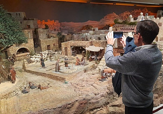 Un hombre fotografía el Belén expuesto en la Fundación Bancaja.