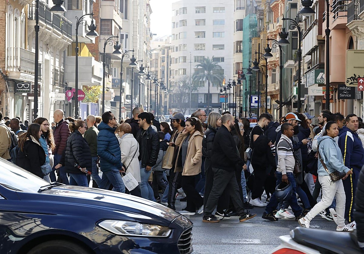 Ríos de personas transitan por la calle Colón, este sábado por la mañana, en busca de compras con rebaja.
