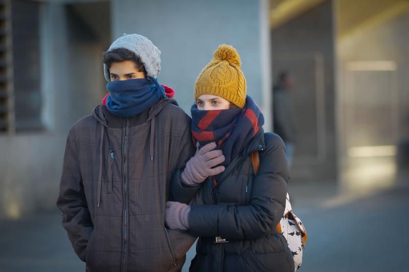 Una pareja se protege del frío.