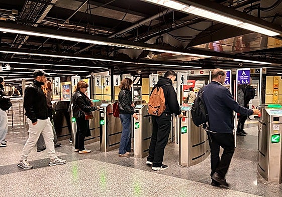 Viajeros validando su billete de metro en la estación de Colón en Valencia.