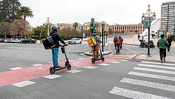 Varios usuarios de un carril bici en el cruce de la Alameda con el puente de la Exposición.