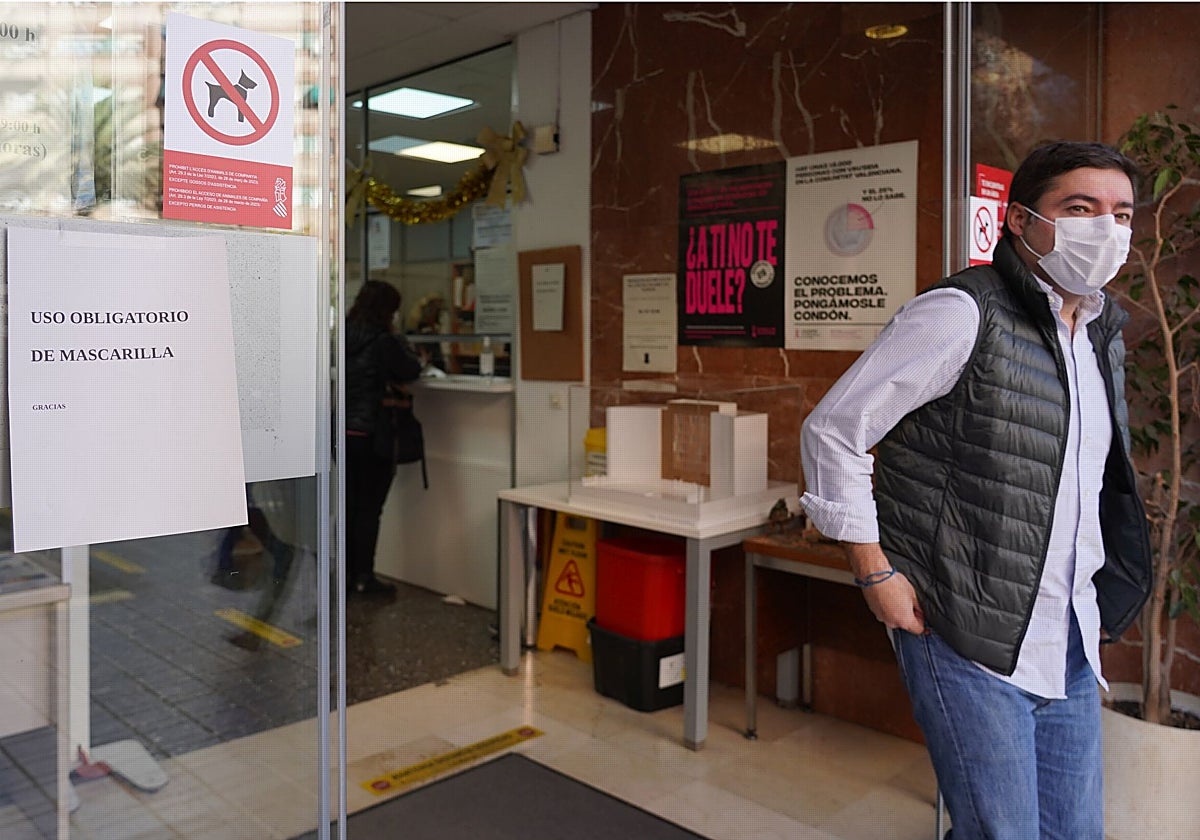 Un hombre sale de un centro sanitario con mascarilla.