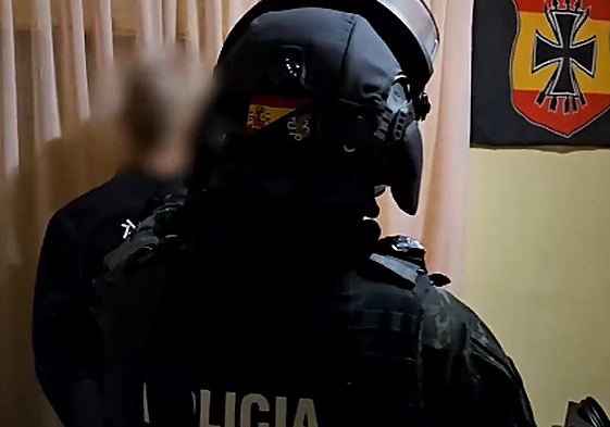 Un policía junto a uno de los detenidos en la operación.