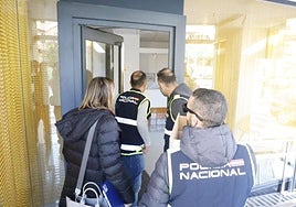 Tres policías y la secretaria judicial entran en la clínica dental para iniciar el registro.