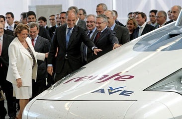 Rita Barberá y Francisco Camps, entre otros, observan el AVE tras su viaje inaugural a Valencia.