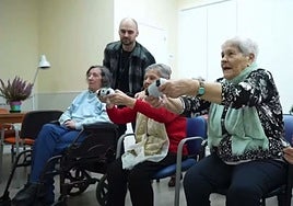 Dos personas mayores con un mando de una consola, en Valencia.