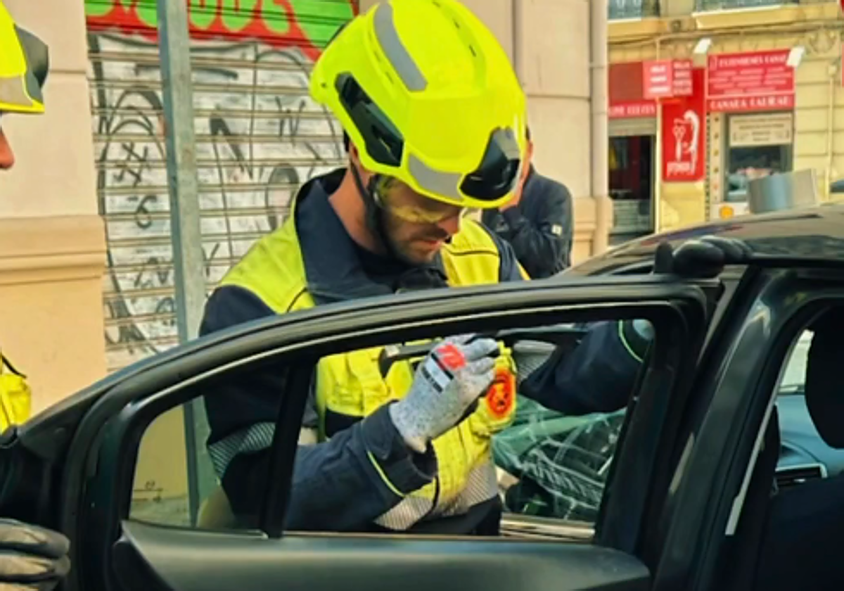 Los bomberos rompen la ventanilla de un coche para rescatar a un niño en el centro de Valencia