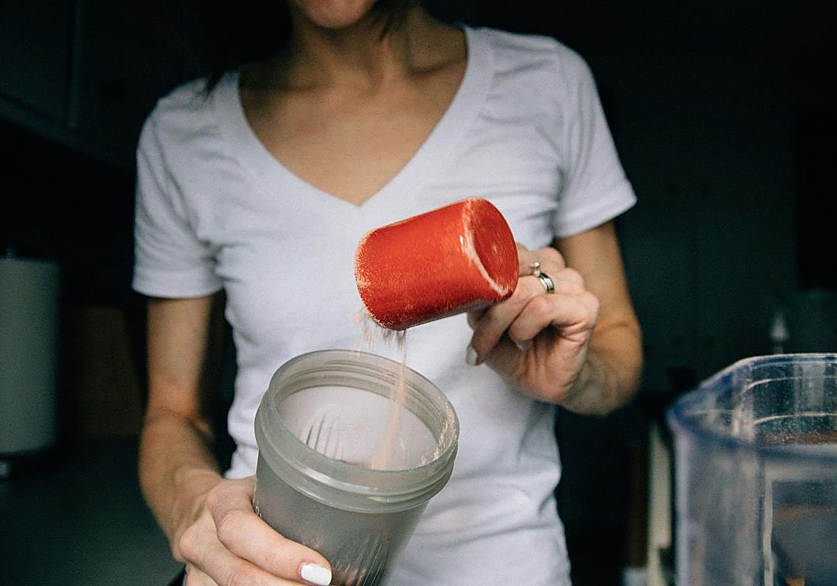Una mujer se prepara un batido de proteínas,