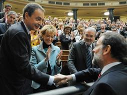El líder del PP, Mariano Rajoy (d), saluda a Zapatero tras ser elegido. /REUTERS