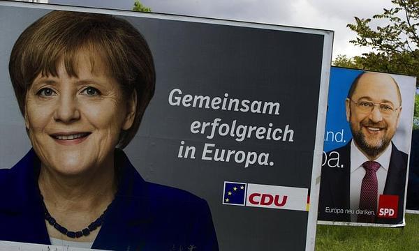 Un cartel de Schulz, tras uno de Merkel