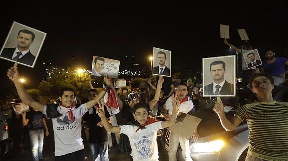 Ciudadanos sirios celebran la victoria de El-Asad. 