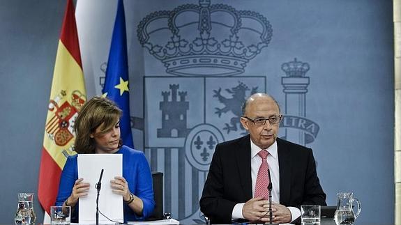 La vicepresidenta del Gobierno, Soraya Sáenz de Santamaría (i), y el ministro de Hacienda y Administraciones Públicas, Cristóbal Montoro (d)