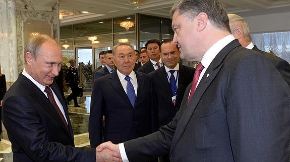 Putin y Poroshenko se estrechan la mano. 