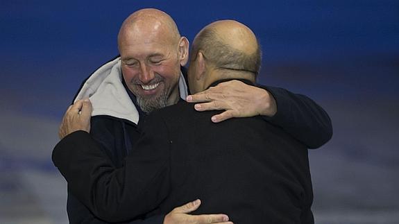 El ciudadano galo Serge Lazarevic (izq), abraza al ministro francés de Defensa, Jean-Yves Le Drian. 