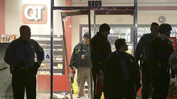 Varios policías inspeccionan una estación de servicio en Berkeley (Misuri). 