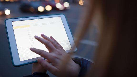 Una mujer consulta su tablet. 