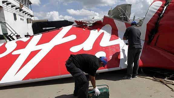 Investigadores inspeccionan los restos del avión de AirAsia. 