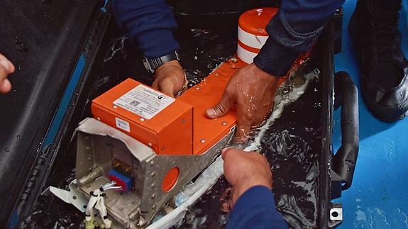 Buzos de la marina manipulan una caja negra del avión de AirAsia siniestrado en diciembre. 