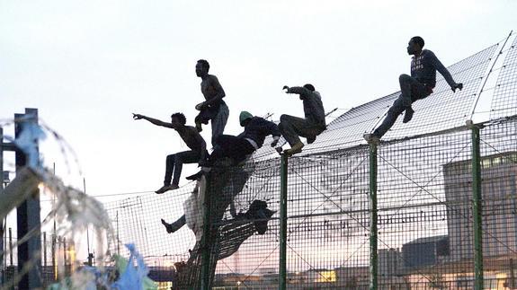 Inmigrantes encaramados a la valla de Melilla.