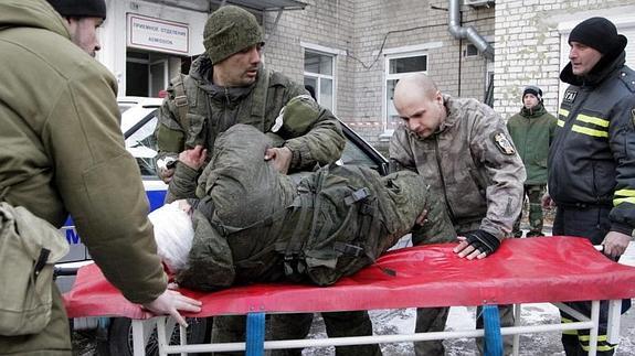 Varios rebeldes separatistas ayudan a un compañero herido cerca de un hospital en Donetsk. 