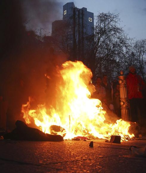 Manifestantes prenden fuego a un montón de basura. 