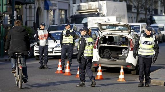 Agentes controlan las matrículas de los vehículos en el centro de París. 