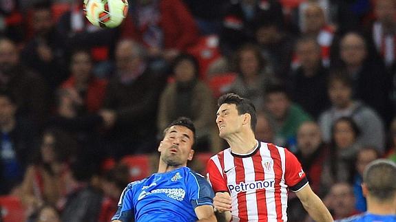 Rodríguez (i) y Aduriz saltan por un balón. 