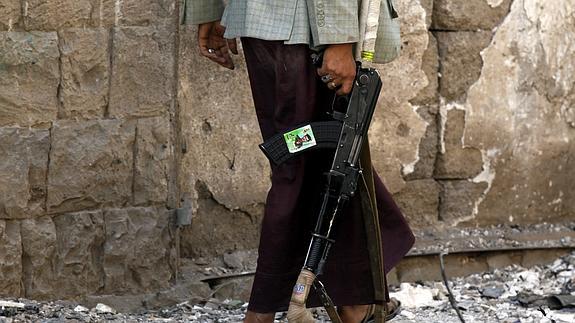 Un miliciano hutí inspecciona el lugar tras explotar un coche bomba en Saná (Yemen).
