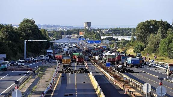 Ganaderos franceses bloquean con camiones y neumáticos una autopista cercana a Lyon. 