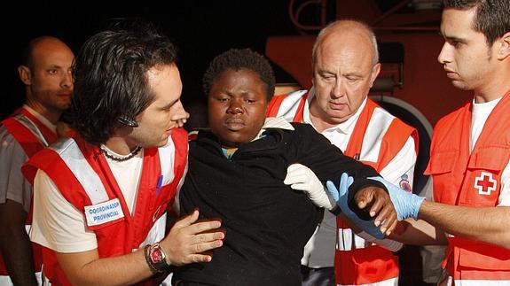 Una inmigrante embarazada es ayudada por miembros de la Cruz Roja.