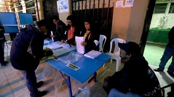 Integrantes de una mesa electoral preparan todo para recibir a los votantes guatemaltecos. 