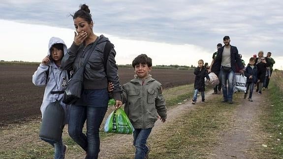 Una familia de inmigrantes sirios camina rumbo a la frontera con Austria.