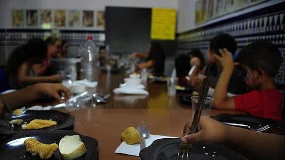 Niños pertenecientes a familias con escasez de recursos almuerzan en un comedor social.