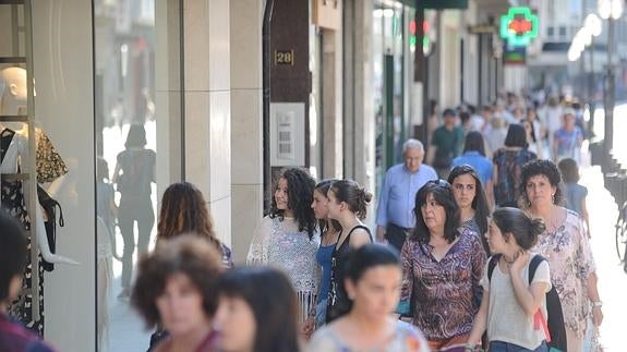 Un grupo de personas paseando por una zona comercial. 