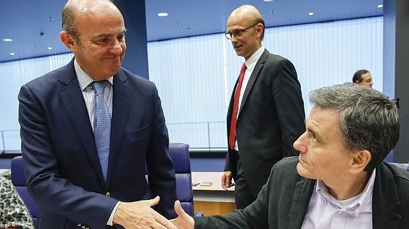 Luis de Guindos saluda a su homólogo griego, Euclides Tsakalotos. 