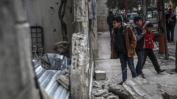 Curiosos inspeccionan los restos tras un ataque aéreo.