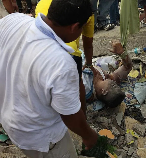 Pobladores rescatan un cuerpo entre los escombros en la localidad de Pedernales (Ecuador). 