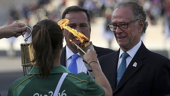 Carlos Arthur Nuzman (d) recibe la antorcha olímpica. 