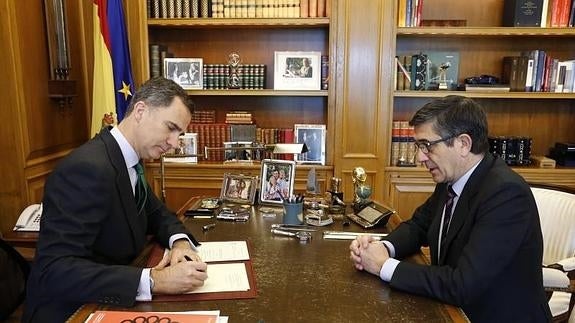 El Rey, firmando el decreto en presencia de Patxi López.