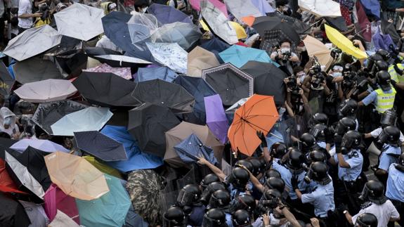Policias antidisturbios intentan movilizar a los miles de manifestantes de la denominada "Revolución de los paraguas".
